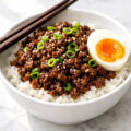 Ground beef bulgogi bowl with rice, sesame seeds, green onions and soft-boiled egg
