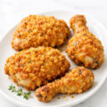 Buttermilk baked chicken with crispy cornflake parmesan coating on white platter