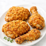 Buttermilk baked chicken with crispy cornflake parmesan coating on white platter