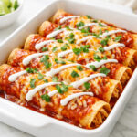Easy chicken enchiladas in a baking dish with melted cheese and red sauce