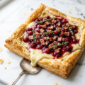 Cranberry brie tart with crispy pancetta and fresh thyme on golden puff pastry