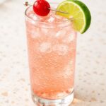 Dirty Shirley cocktail in tall glass with cherry garnish