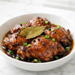 Filipino chicken adobo with dark glossy soy vinegar glaze in a white bowl