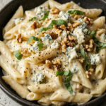 Bowl of creamy gorgonzola pasta with sage garnish