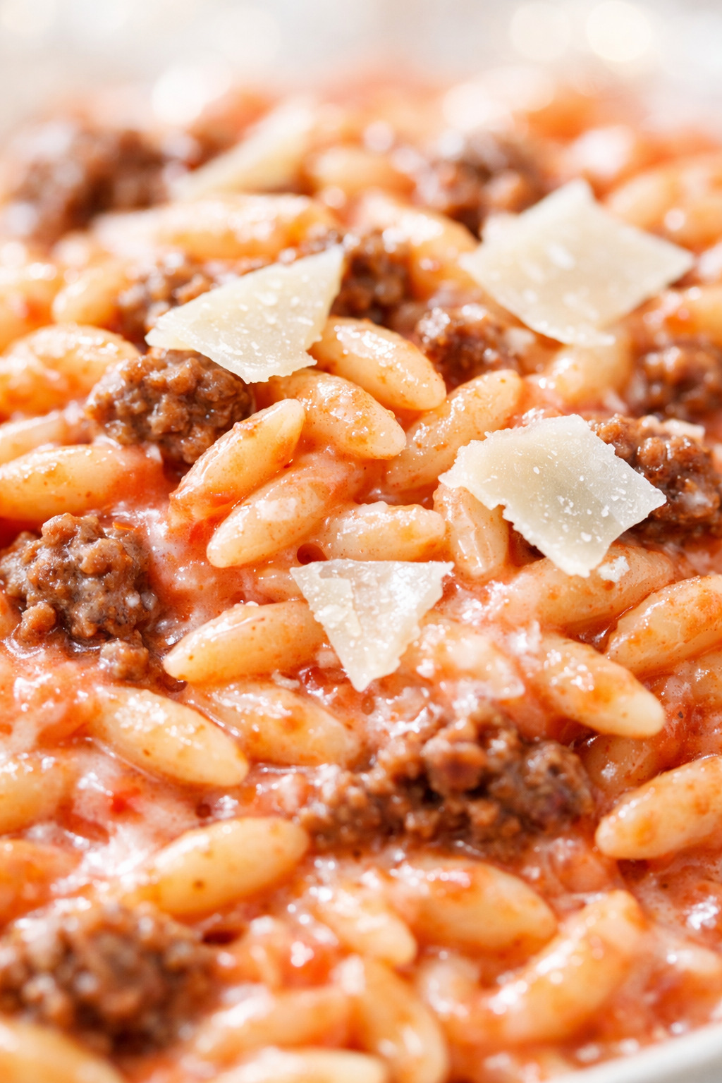 Closeup of a spoonful of ground beef orzo with creamy tomato sauce
