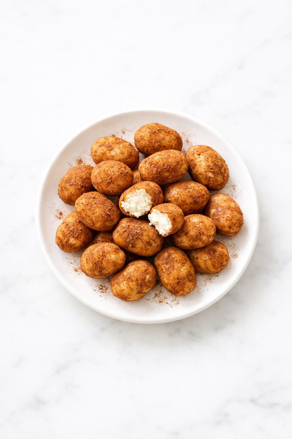 Irish Potato Candy dusted in cinnamon on white ceramic plate