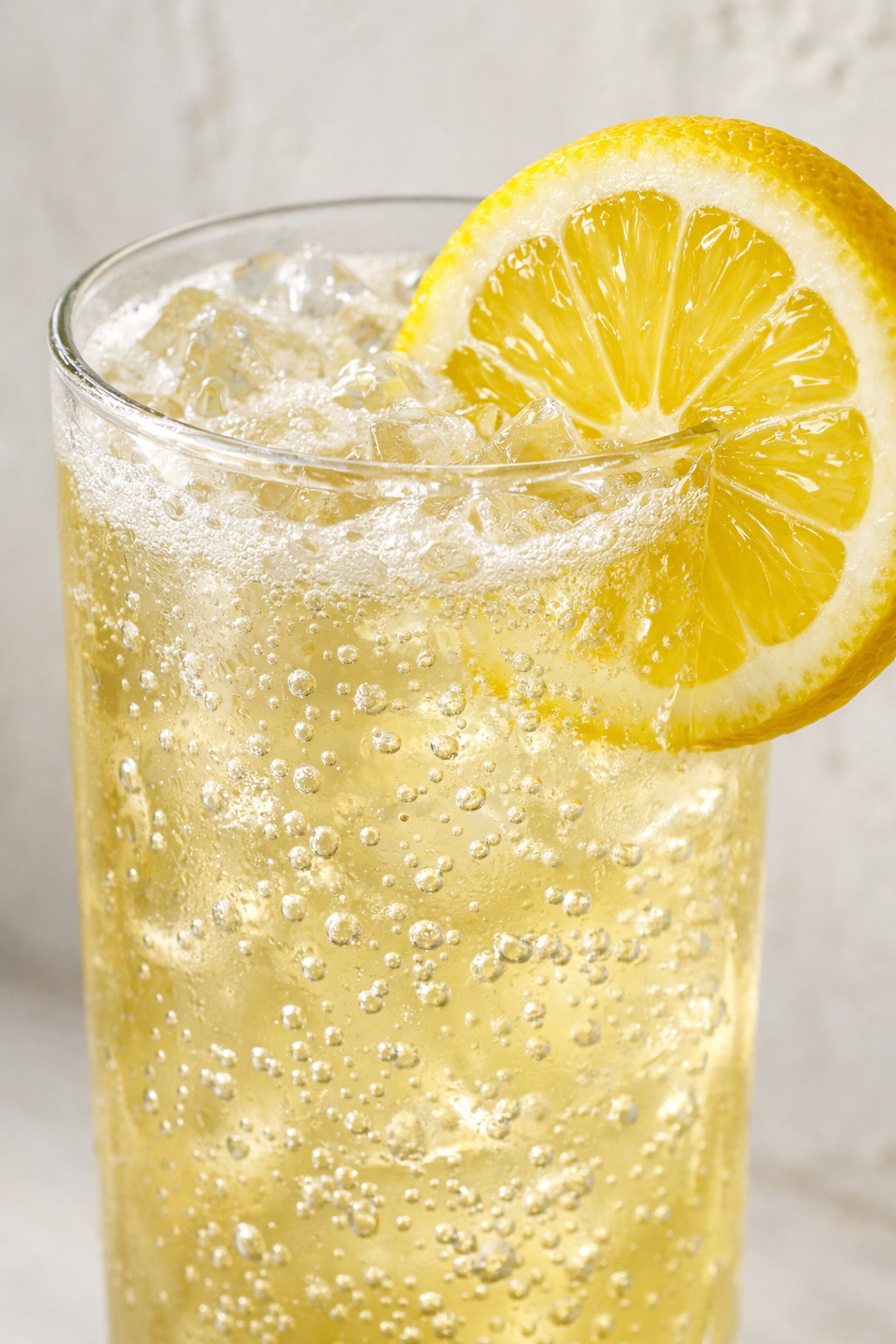 Close-up of John Collins cocktail bubbles and lemon garnish detail