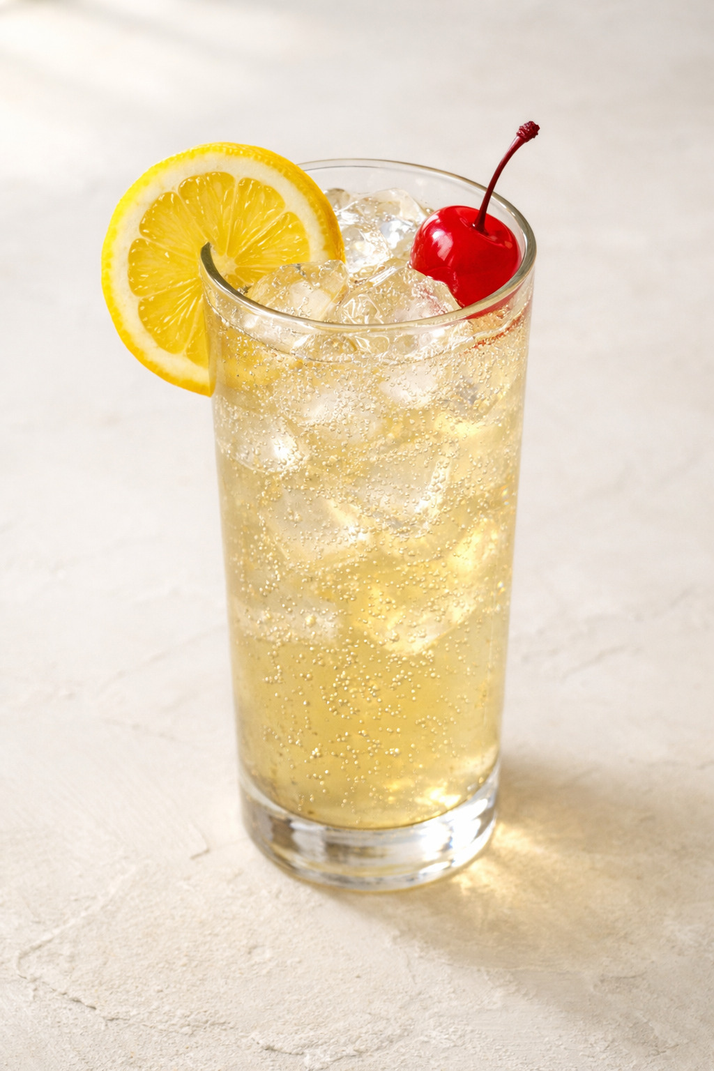 John Collins Cocktail in a tall Collins glass with lemon wheel garnish and ice