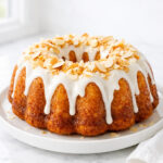 Louisiana crunch cake on a white plate with glaze and toasted coconut