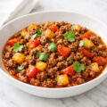 Mexican picadillo with ground beef potatoes and tomatoes in a white bowl
