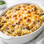 Cheesy ranch rotini bake with beef and sweet corn in a white baking dish
