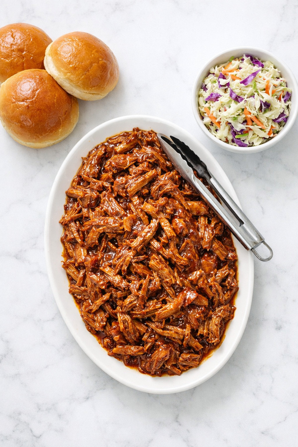 Overhead view of root beer pulled pork platter with buns and coleslaw