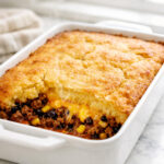 Texas tamale pie casserole in a baking dish with golden cornbread crust
