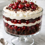 Black Forest trifle in clear glass bowl with chocolate, cherry and cream layers