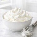 Freshly whipped cream in white bowl