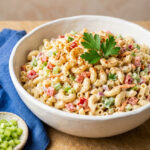 Creamy macaroni salad in a glass bowl with paprika on top